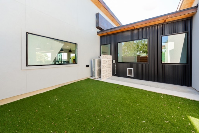 back of property featuring central air condition unit and a yard