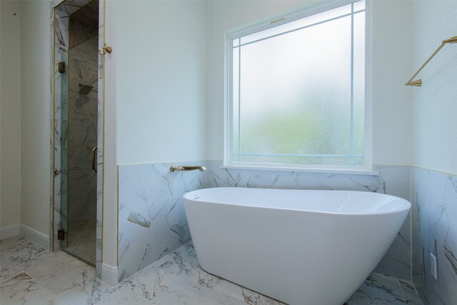 bathroom with tile walls and plus walk in shower