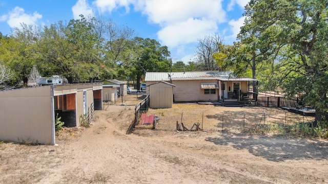 back of house with a storage shed