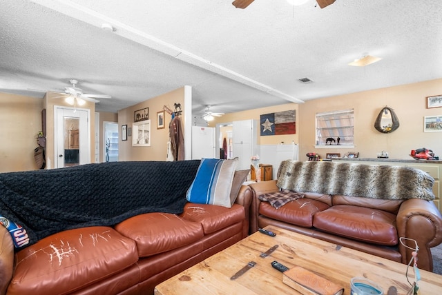 living room featuring ceiling fan and a textured ceiling