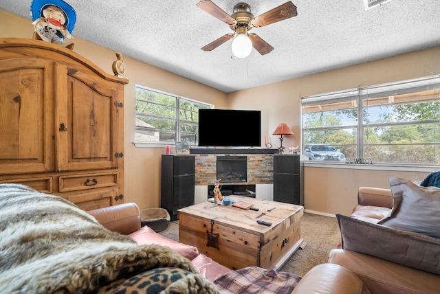 carpeted living room featuring a textured ceiling, a fireplace, and ceiling fan