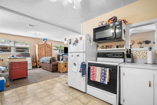 kitchen featuring white appliances, light carpet, a textured ceiling, and ceiling fan