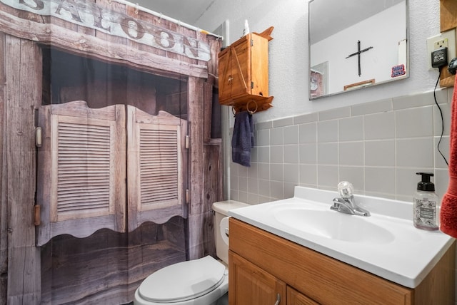 bathroom featuring tile walls, tasteful backsplash, toilet, and vanity