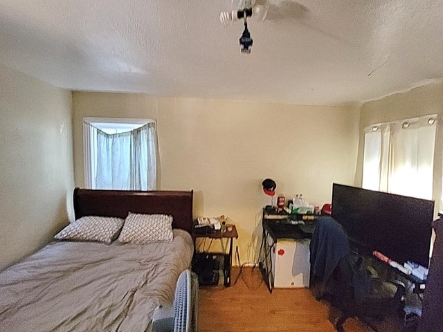 bedroom with a textured ceiling and wood-type flooring