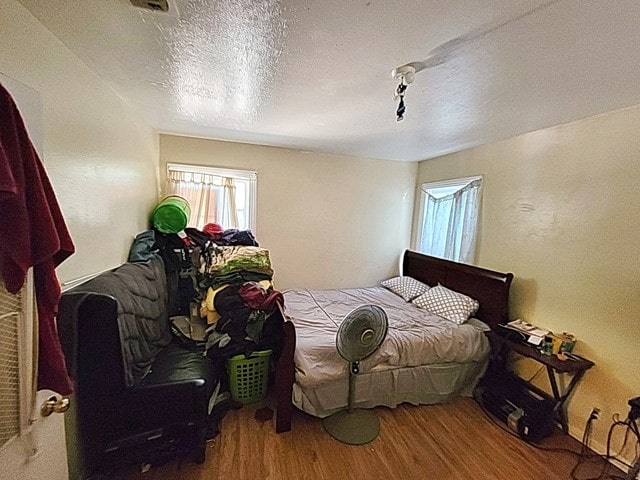 bedroom featuring a textured ceiling and hardwood / wood-style flooring