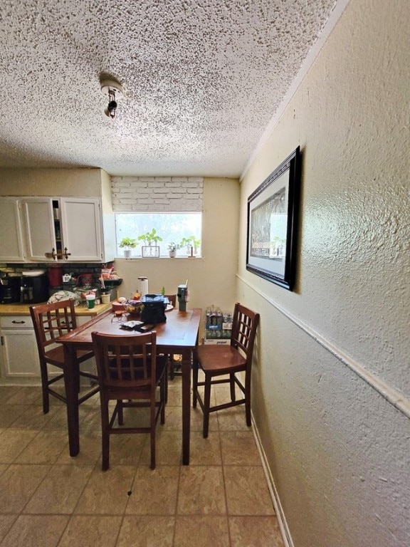 tiled dining space with a textured ceiling