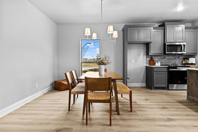 dining room with an inviting chandelier and light hardwood / wood-style floors