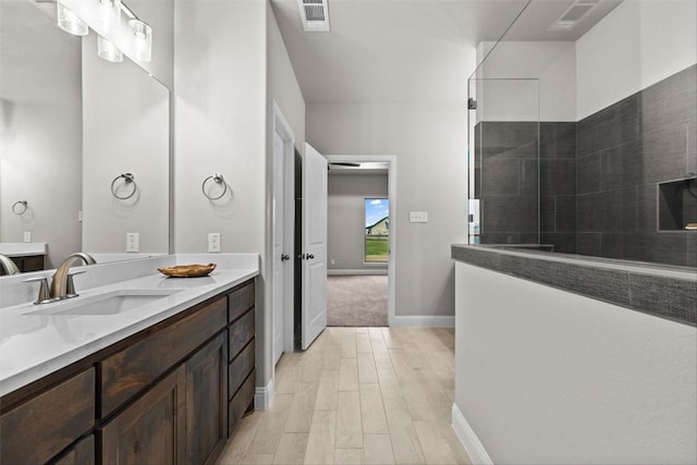 bathroom featuring walk in shower, vanity, and hardwood / wood-style floors