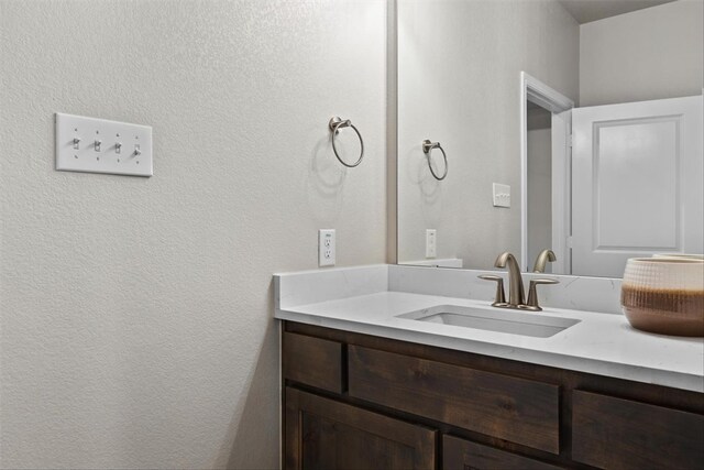 bathroom with hardwood / wood-style flooring, vanity, and a tile shower