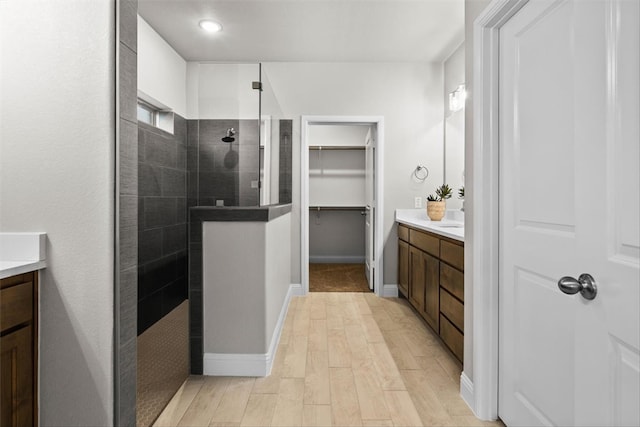 bathroom with vanity, wood-type flooring, and a tile shower