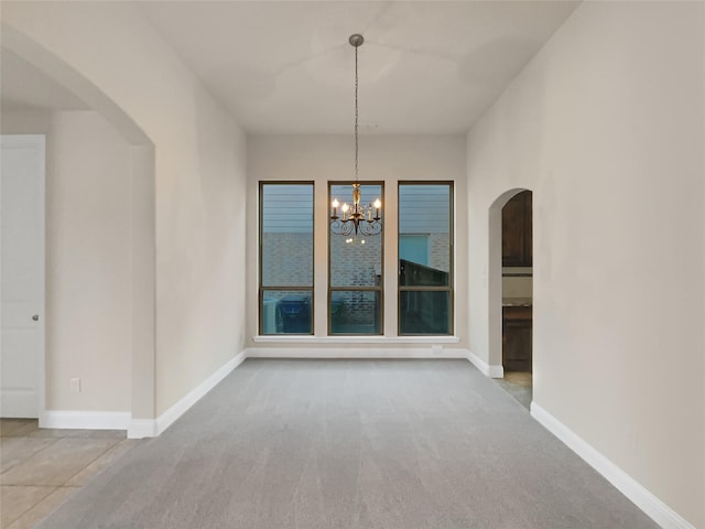 unfurnished dining area with a notable chandelier and carpet flooring