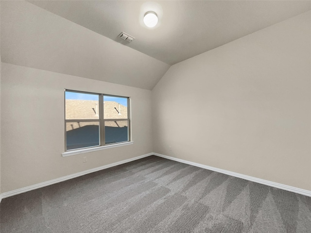 carpeted empty room with lofted ceiling