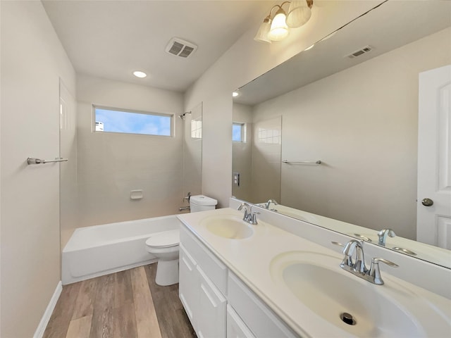 full bathroom with wood-type flooring, toilet, tub / shower combination, and vanity