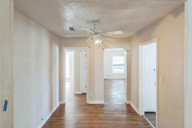 corridor featuring dark wood-type flooring and a textured ceiling