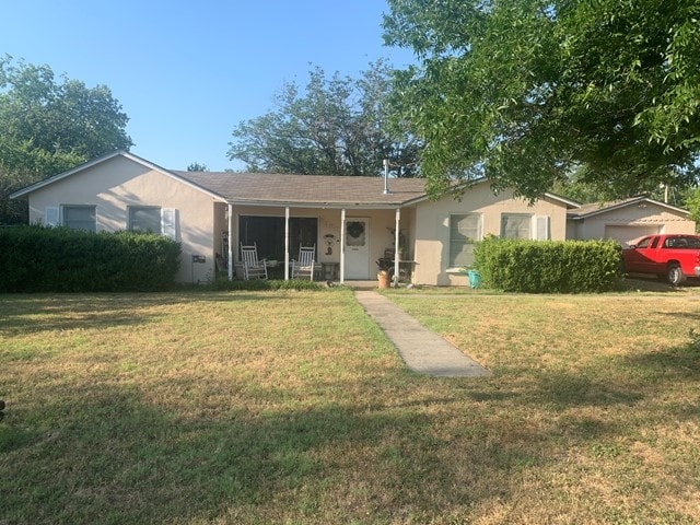 rear view of house with a porch and a yard