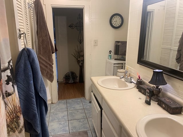 bathroom with tile flooring and dual vanity