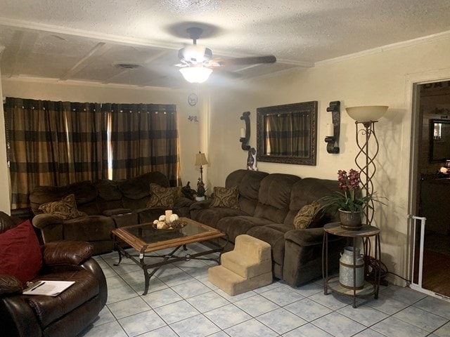 tiled living room featuring ceiling fan, a textured ceiling, and ornamental molding