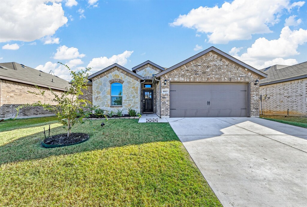 view of front of property featuring a front yard and a garage