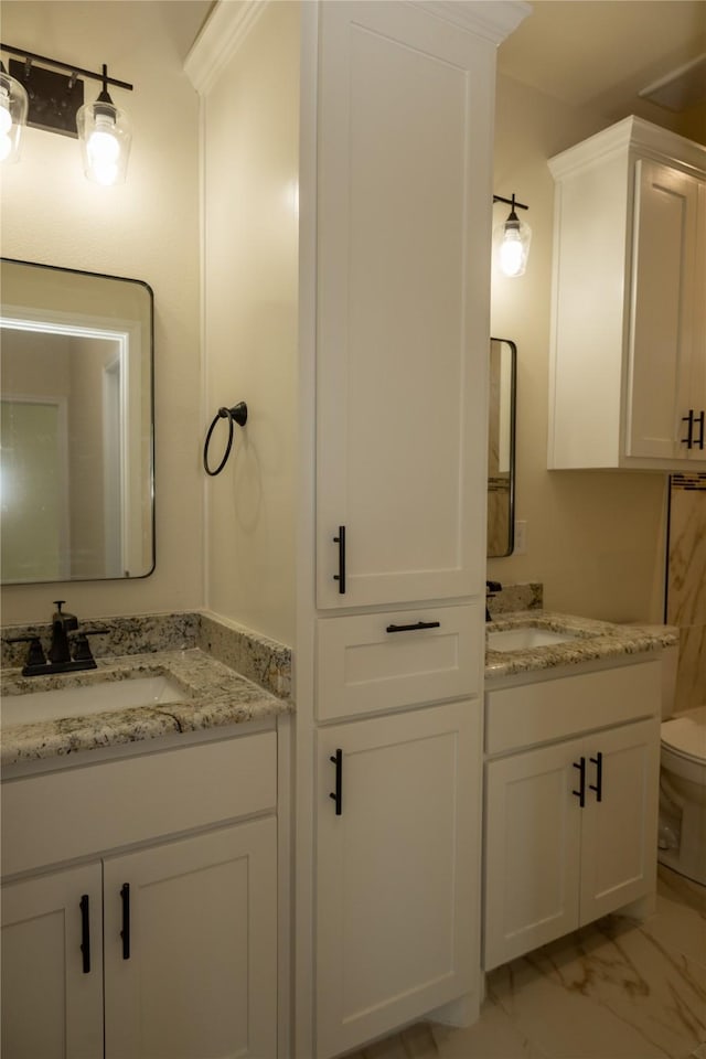 bathroom with two vanities, marble finish floor, and a sink