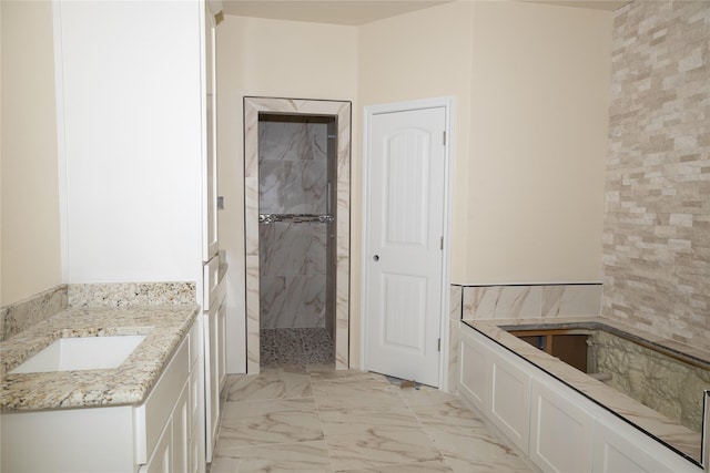 full bath featuring a garden tub, marble finish floor, tiled shower, and vanity