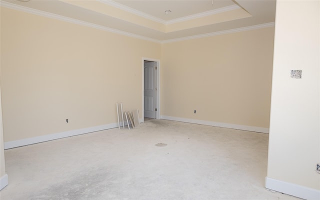 unfurnished room with a tray ceiling, ornamental molding, and baseboards