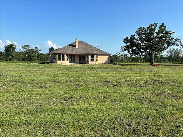 back of property with a lawn and a chimney