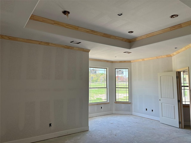 unfurnished room featuring crown molding, a tray ceiling, and baseboards