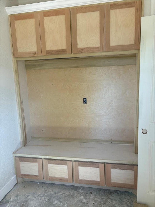 mudroom featuring baseboards and unfinished concrete floors