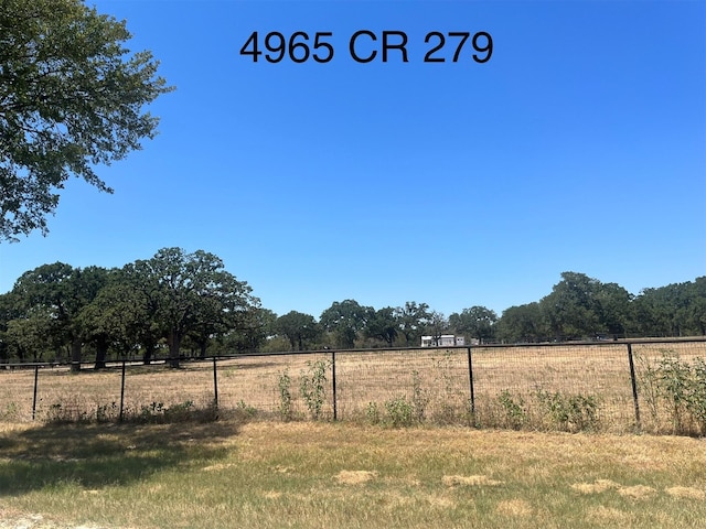view of yard featuring fence and a rural view