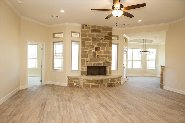 unfurnished living room featuring wood finished floors, ceiling fan with notable chandelier, a stone fireplace, and crown molding