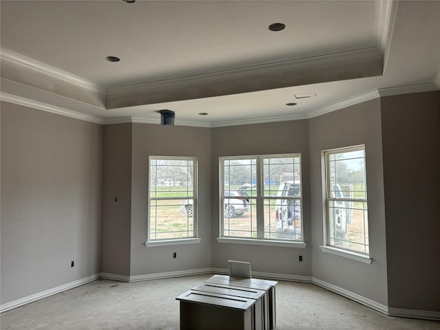 spare room featuring baseboards, a tray ceiling, and crown molding