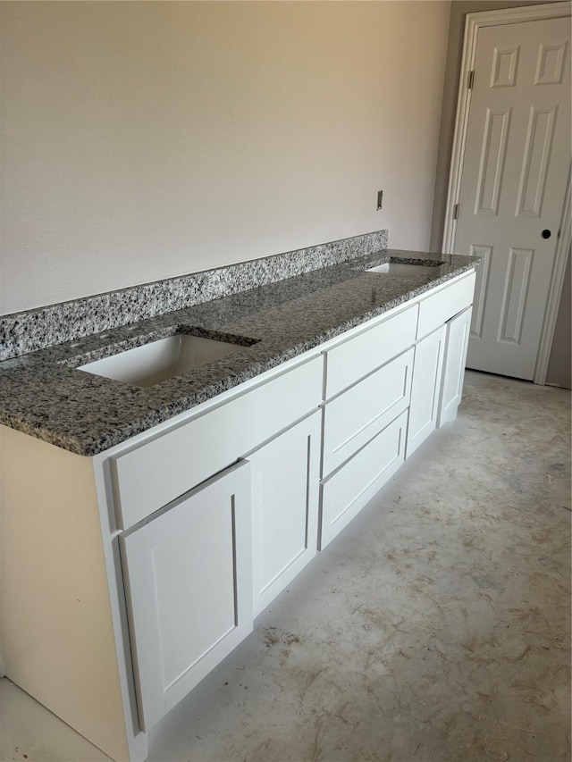 bathroom with unfinished concrete floors and a sink