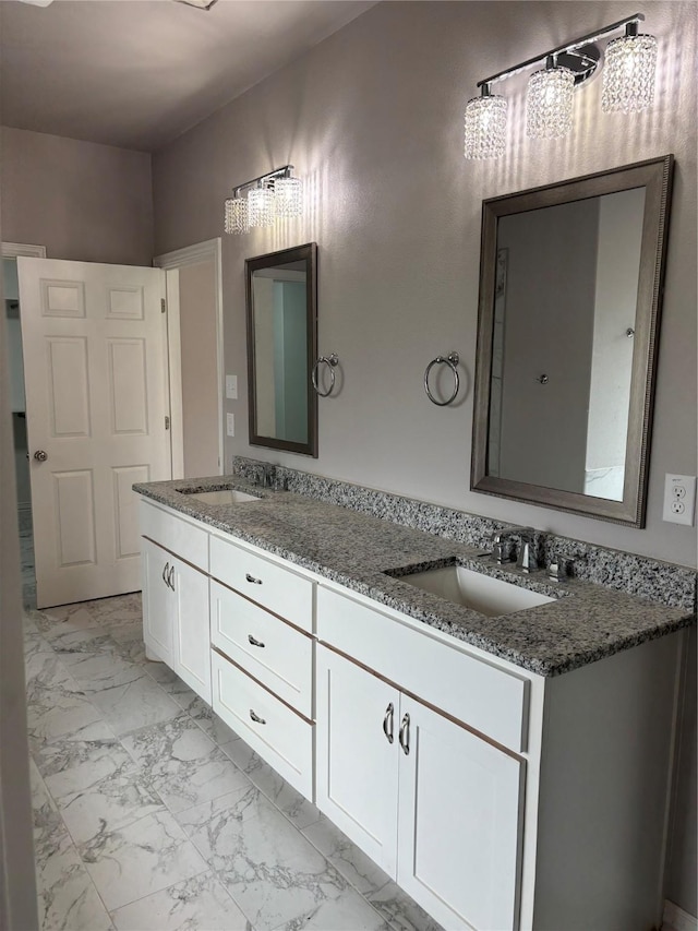 full bathroom featuring marble finish floor, double vanity, and a sink