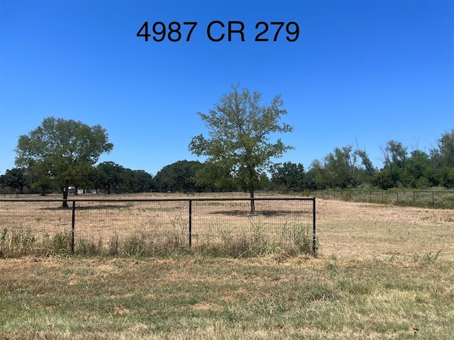 view of yard with a rural view and fence