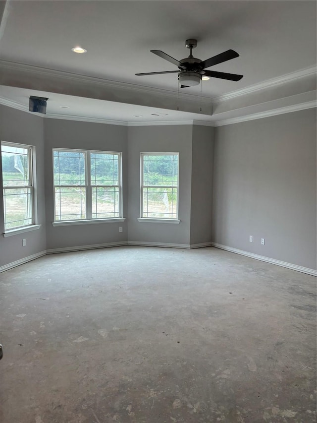 spare room featuring a tray ceiling, plenty of natural light, and baseboards