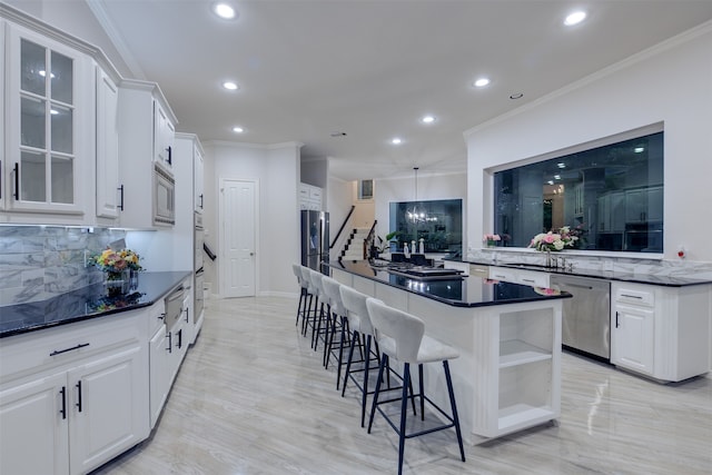 kitchen with white cabinets, decorative backsplash, ornamental molding, and stainless steel appliances