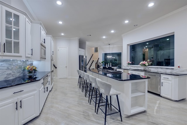 kitchen with white cabinets, appliances with stainless steel finishes, a breakfast bar, glass insert cabinets, and crown molding