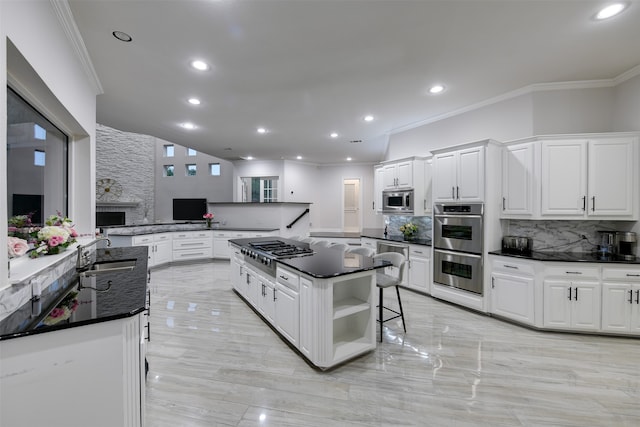 kitchen featuring a kitchen bar, sink, backsplash, stainless steel appliances, and kitchen peninsula