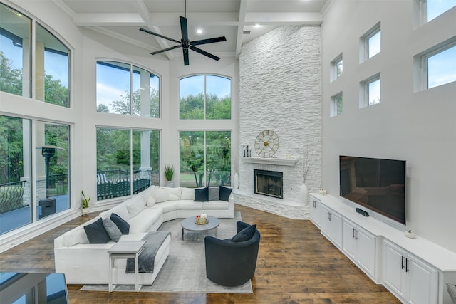 living room featuring a high ceiling, a fireplace, beam ceiling, dark hardwood / wood-style floors, and coffered ceiling