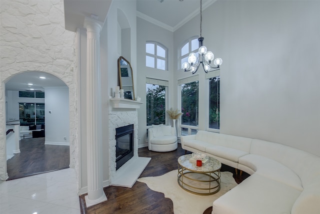 living room with a fireplace, high vaulted ceiling, a chandelier, and wood-type flooring