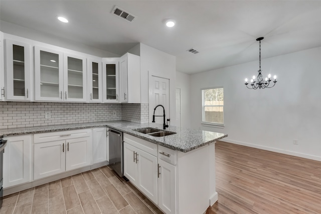 kitchen featuring light stone countertops, backsplash, sink, dishwasher, and white cabinets