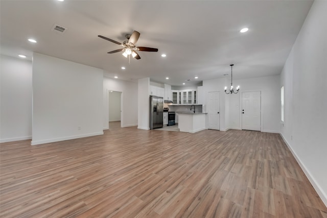 unfurnished living room featuring light hardwood / wood-style flooring, ceiling fan with notable chandelier, and sink