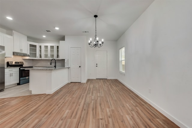 kitchen featuring light stone countertops, stainless steel appliances, an inviting chandelier, light hardwood / wood-style flooring, and white cabinetry