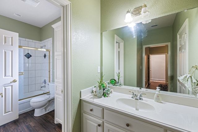 full bathroom with hardwood / wood-style floors, toilet, enclosed tub / shower combo, and vanity