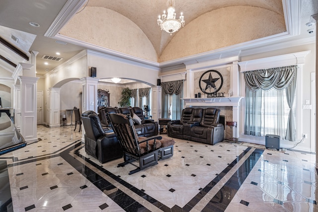 living room with a notable chandelier, crown molding, decorative columns, light tile patterned floors, and a tile fireplace