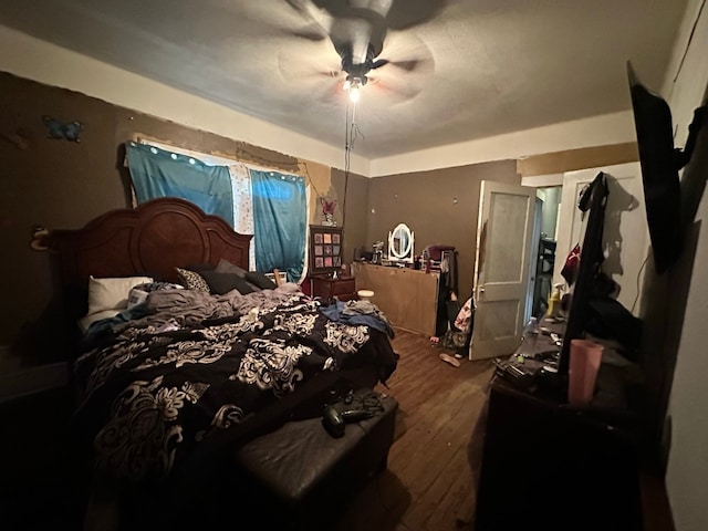 bedroom with dark hardwood / wood-style flooring and ceiling fan