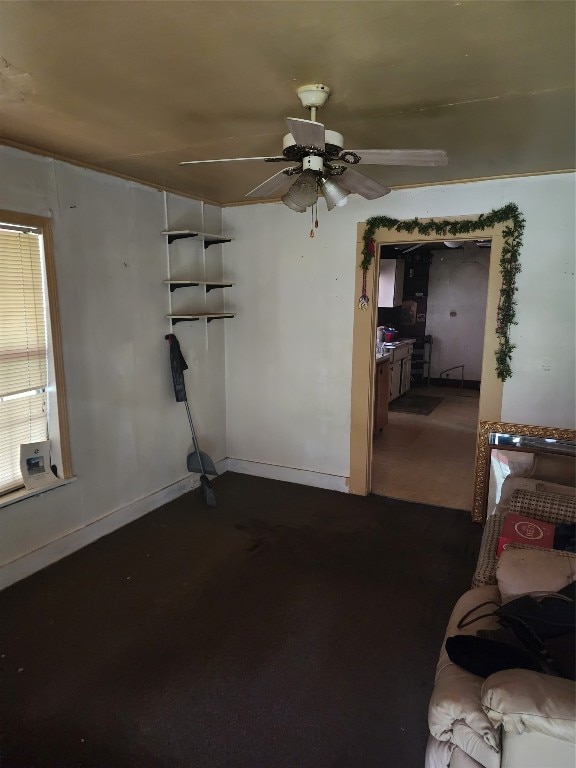 unfurnished living room with ceiling fan, dark carpet, and a wealth of natural light