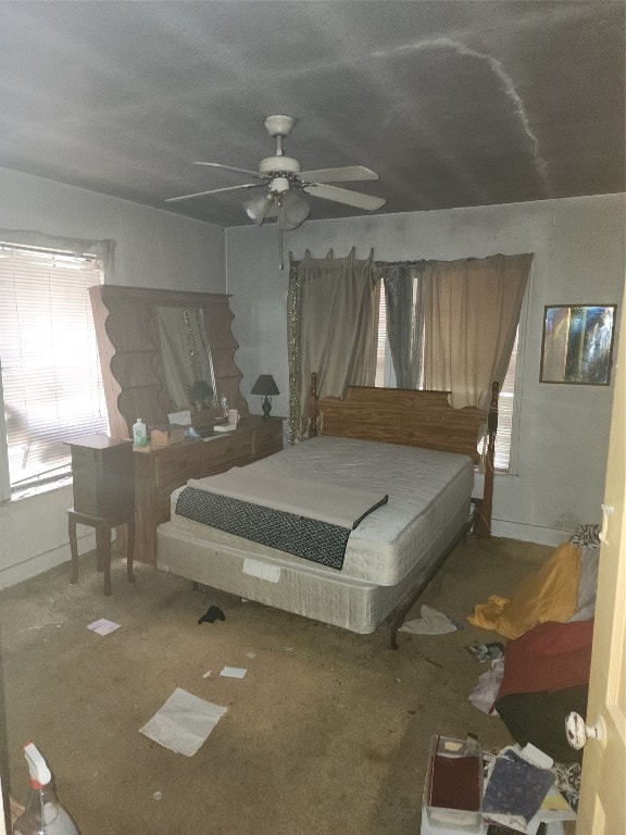 bedroom with dark carpet, ceiling fan, and multiple windows