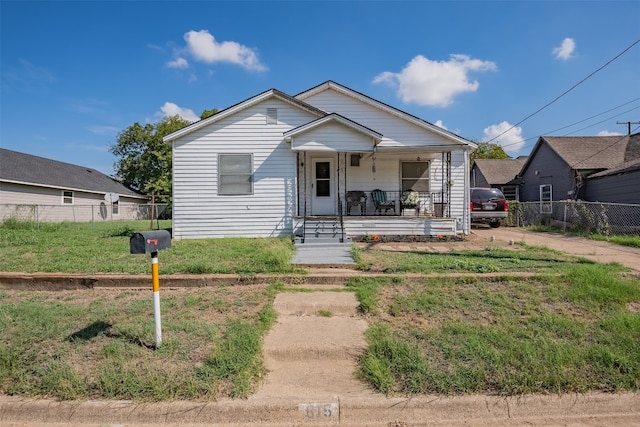 bungalow with a porch and a front lawn