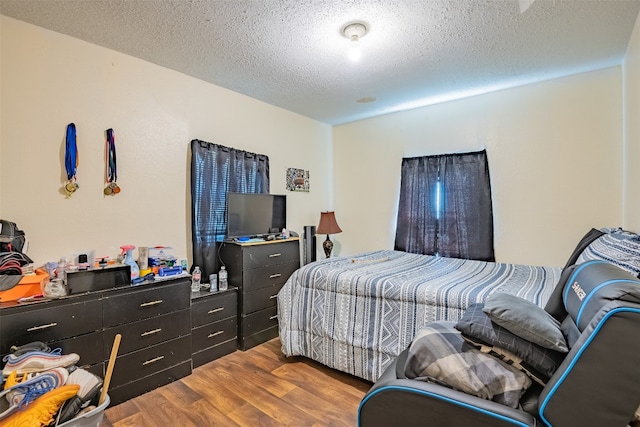 bedroom featuring hardwood / wood-style flooring and a textured ceiling